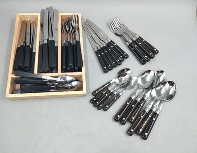 des couteaux, des cuillères et des fourchettes dans une boîte en bois posée sur une table