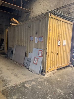un conteneur jaune posé au milieu d'un immeuble