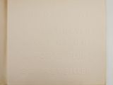 an open book sitting on top of a table next to a white wall