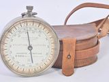 a pocket watch with a strap around it on a white surface