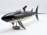 a black and white model of a shark with a man in a boat
