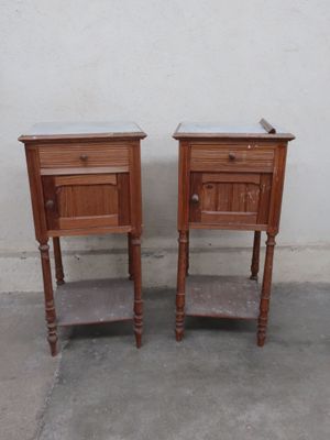 two small wooden tables with marble tops on them
