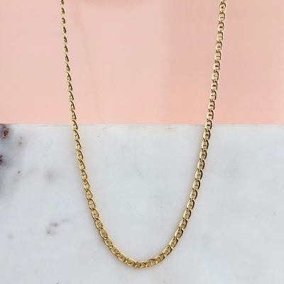 un collier à chaîne en or posé sur une surface en marbre