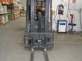 a forklift in a warehouse with pallets in the background