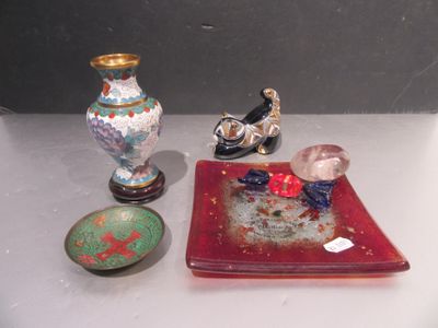 une assiette rouge ornée d'un oiseau, à côté de deux vases et d'une assiette ornée d'un oiseau