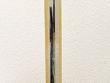a metal sculpture on a wooden table with a white wall behind it