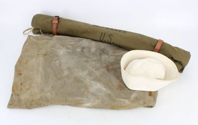 un chapeau et un sac enroulé posés par terre