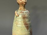 a ceramic vase with a cat on the top of it