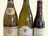 trois bouteilles de vin posées l'une à côté de l'autre sur une table