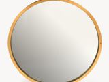 a round mirror with a gold frame on a white background