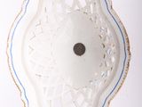 a white bowl with blue trim on a white surface