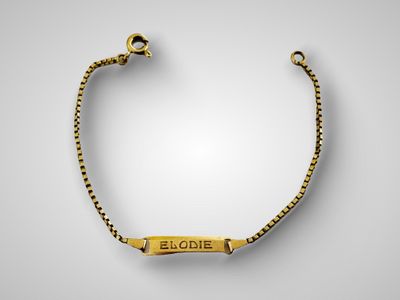 un bracelet plaqué or orné d'une plaque portant un nom