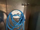 un tuyau bleu fixé au mur d'une salle de bains