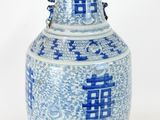 un vase bleu et blanc posé sur une surface blanche