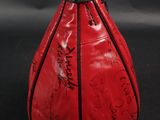 a close up of a red bag with writing on it on a black background