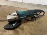 an electric angle grinder sitting on top of a wooden floor