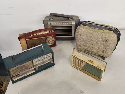 de nombreux modèles différents de radios d'époque posées sur la table