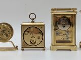 several different types of clocks sitting on top of a white surface