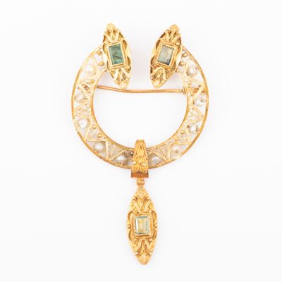 an image of a gold broochle with emeralds and pearls