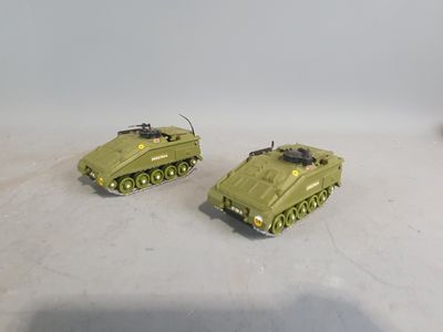 two green toy tanks sitting on a white surface