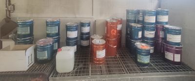 de nombreux pots de peinture posés sur une étagère dans une pièce