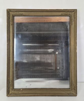 une image d'un miroir encadré d'or sur un mur blanc