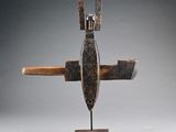 une sculpture en bois représentant un avion à deux ailes, posée sur un socle