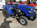 a blue tractor that is parked in the dirt