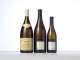 three bottles of wine are lined up on a table