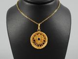 un collier plaqué or, de forme circulaire, orné d'une pierre bleue