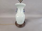 a white vase with a flower in it on a table