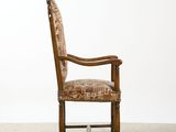 an old wooden chair with a patterned upholstered seat