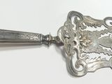 une cuillère en argent posée sur une table blanche