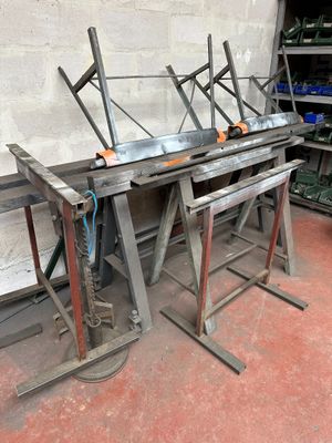 many pieces of metal sitting on a table in a workshop