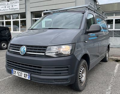 a grey van parked in a parking lot in front of a building