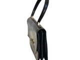 the black purse has a gold clasp on the handle
