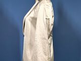beige jacket on a mannequin stand against a blue background