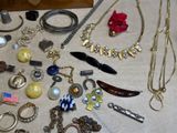 many different types of necklaces and bracelets laid out on a table