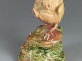 une figurine représentant un oiseau perché sur un tas de feuilles