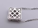 silver necklace with a celtic design on a chain on a gray surface