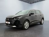 un SUV gris garé dans une grande pièce au sol noir