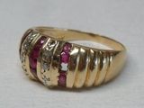 bague en or jaune sertie de rubis et de diamants sur un fond blanc