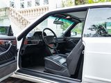 a white car with its door open next to a white car