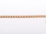 un bracelet en chaîne d'or orné d'une breloque en forme de pièce de monnaie