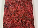 red and black marbled paper on a white surface with a white frame