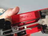 a person holding a red tool in their hand