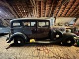une vieille voiture qui est garée par terre dans un garage