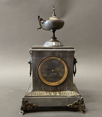 a silver clock with a bird on top of it