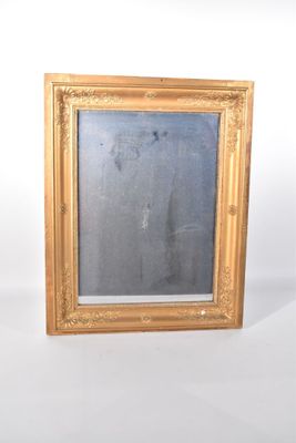 une photo d'un miroir à cadre doré accroché au mur