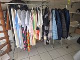 a lot of clothes hanging on a rack in a room